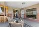 Relaxing patio features rocking chairs, a woven ottoman, brick accents, and entrances to both the house and sunroom at 3035 E Maplewood Ave, Centennial, CO 80121
