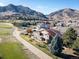 Beautiful aerial view of a home, green lawns, mature trees and snow-capped mountain views at 16226 River Haven Way, Morrison, CO 80465