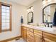 Double sink bathroom vanity featuring shaker cabinets and framed mirrors at 16226 River Haven Way, Morrison, CO 80465