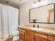 Bright bathroom featuring wood cabinets, solid surface countertop, a rectangular mirror, and a shower with curtain at 16226 River Haven Way, Morrison, CO 80465