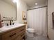 Well-lit bathroom features a modern vanity with black hardware and a shower with patterned curtain at 16226 River Haven Way, Morrison, CO 80465