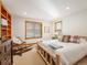 Bedroom featuring a bed, cowhide rug, side tables, and several windows at 16226 River Haven Way, Morrison, CO 80465