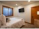 Bedroom with neutral colored walls and carpet featuring a wall-mounted TV at 16226 River Haven Way, Morrison, CO 80465