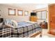 Bedroom with natural-wood trim featuring a bed, dresser with TV, and windows at 16226 River Haven Way, Morrison, CO 80465