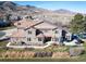 Stunning two-story home with a stone and stucco exterior, lush landscaping, and a tile roof against a mountain backdrop at 16226 River Haven Way, Morrison, CO 80465