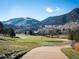 Picturesque view of a golf course with rolling hills and mountains in the distance, surrounded by lush trees at 16226 River Haven Way, Morrison, CO 80465