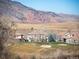 Scenic view of a home overlooking a lush golf course, with mountains in the background on a sunny day at 16226 River Haven Way, Morrison, CO 80465