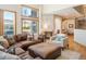 Inviting living room area featuring a large sectional sofa, an ottoman, hardwood floors and oversized windows at 16226 River Haven Way, Morrison, CO 80465