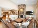 Inviting living room featuring a stone fireplace, hardwood floors, and an open layout to the kitchen and staircase at 16226 River Haven Way, Morrison, CO 80465