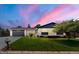 Charming single-story home featuring a well-maintained lawn, brick facade, and attached garage with a beautiful sunset backdrop at 13010 W 6Th Pl, Golden, CO 80401