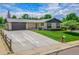 Charming single-story home with a well-manicured lawn, a long driveway, and an attached garage at 13010 W 6Th Pl, Golden, CO 80401