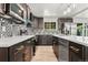 Kitchen showcasing modern appliances, granite countertops, stylish backsplash, and dark cabinets with gold hardware at 13010 W 6Th Pl, Golden, CO 80401