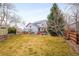 Expansive backyard with lush lawn, mature trees, wooden fence, and a patio area for outdoor entertaining at 6071 Russell Ln, Arvada, CO 80403