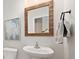 Charming powder room with a decorative mirror and a classic pedestal sink and clean finishes at 6071 Russell Ln, Arvada, CO 80403