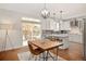 Bright dining area features hardwood floors, a wood table, and sliding glass doors to the backyard patio at 6071 Russell Ln, Arvada, CO 80403