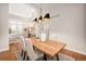 Bright dining room with wooden table, modern light fixture, and entry view at 6071 Russell Ln, Arvada, CO 80403