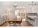 Bright dining area features hardwood floors, a wood table, and sliding glass doors to the backyard at 6071 Russell Ln, Arvada, CO 80403