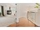 Bright hallway with hardwood floors transitioning to a carpeted living space with fireplace at 6071 Russell Ln, Arvada, CO 80403