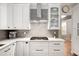 Well-equipped kitchen with stainless steel appliances, quartz counters, and white cabinetry at 6071 Russell Ln, Arvada, CO 80403