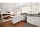 Open-concept kitchen features quartz counters and stainless appliances with an adjacent living area at 6071 Russell Ln, Arvada, CO 80403