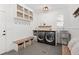 Functional laundry room with custom cabinets, a utility sink, and a folding bench at 6071 Russell Ln, Arvada, CO 80403