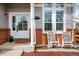 Welcoming front porch featuring rocking chairs, brick accents, and a charming entrance at 6071 Russell Ln, Arvada, CO 80403