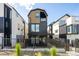 Modern home with a metal fence, black accents, and tan siding at 3433 Lawrence St # 1, Denver, CO 80205