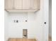 Minimalist laundry room features white walls, wood floors, and ample storage space at 3433 Lawrence St # 1, Denver, CO 80205