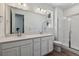 Bathroom featuring a double vanity, a large mirror, and a glass enclosed shower at 8241 Rockvale Dr, Littleton, CO 80125