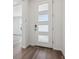 Modern white front door with glass inserts, complemented by sleek hardwood flooring at 8241 Rockvale Dr, Littleton, CO 80125