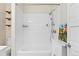 Updated bathroom with white tile, bathtub and shower, with open shelving for storage at 2339 Lowell Blvd, Denver, CO 80211