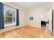 A simple bedroom with hardwood floors and window with curtains leading into another room at 2339 Lowell Blvd, Denver, CO 80211