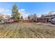 Expansive backyard featuring a well-maintained lawn, mature trees, a playset, and a fenced perimeter at 6532 S Ogden St, Centennial, CO 80121