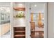 Hallway view to a bright Bedroom room with a crib and rocking chair, and a bathroom featuring wooden shelves at 6532 S Ogden St, Centennial, CO 80121