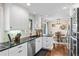 Open-concept kitchen with white cabinets, stainless steel appliances, and a view into the dining area at 6532 S Ogden St, Centennial, CO 80121