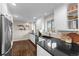 Well-lit kitchen featuring white cabinets, granite countertops, stainless steel appliances, and stylish decor at 6532 S Ogden St, Centennial, CO 80121