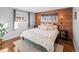 Bright main bedroom featuring hardwood floors, a wood accent wall, and large windows for natural light at 6532 S Ogden St, Centennial, CO 80121