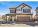 Two-story house with beige and brown siding, a two-car garage, and a paved driveway at 16142 E 111Th Dr, Commerce City, CO 80022