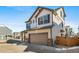 Two-story house with beige and brown siding, a two-car garage, and a paved driveway at 16142 E 111Th Dr, Commerce City, CO 80022