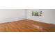 Bright bedroom featuring hardwood floors, white walls, and a large window, providing a cozy and inviting atmosphere at 14936 E Arizona Pl, Aurora, CO 80012