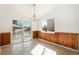 Bright dining area featuring tile floors, beadboard paneling, a modern chandelier, and sliding doors to an outdoor deck at 14936 E Arizona Pl, Aurora, CO 80012