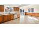 Bright, open kitchen showcasing modern appliances, wood cabinets, tile floors, and a seamless flow to the dining area at 14936 E Arizona Pl, Aurora, CO 80012