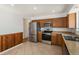 Modern kitchen with stainless steel appliances, updated countertops, and wood cabinets on tile floor at 14936 E Arizona Pl, Aurora, CO 80012