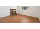 Cozy living room with hardwood floors, a brick fireplace, and a sunlit window at 14936 E Arizona Pl, Aurora, CO 80012