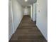 Hallway with wood floors, leading to a white front door with white walls throughout at 22057 E 39Th Pl, Aurora, CO 80019