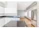 Bright, modern kitchen features white cabinetry, a black countertop and stainless-steel appliances at 70 W 6Th Ave # 109, Denver, CO 80204