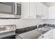 Updated kitchen with stainless steel appliances, dark countertops, and white cabinets at 70 W 6Th Ave # 109, Denver, CO 80204