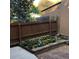 Backyard featuring a small flowerbed with blooming flowers, a wooden fence, and a glimpse of surrounding greenery at 995 W Peakview Cir, Littleton, CO 80120