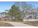 View of the townhouse exterior, showcasing trees, a white fence, and outdoor space at 9139 W 50Th Ln # 204, Arvada, CO 80002