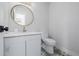 Stylish powder room featuring modern fixtures, a round mirror, and patterned floor tiles at 37 Wagner Cir, Boulder, CO 80304